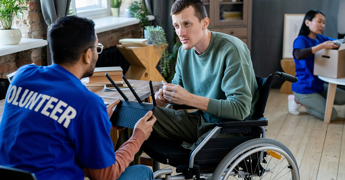 Volunteer working with a man in a wheel chair